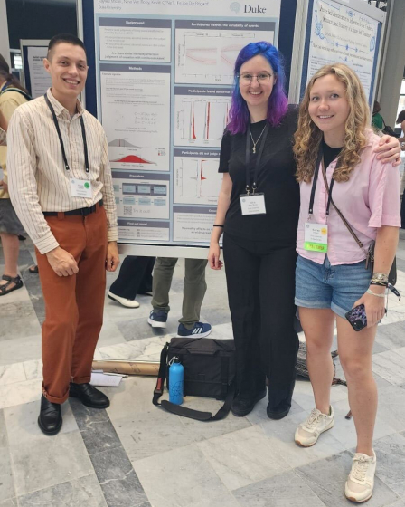 Nina stands by her poster with collaborators Kevin and Kaylee.