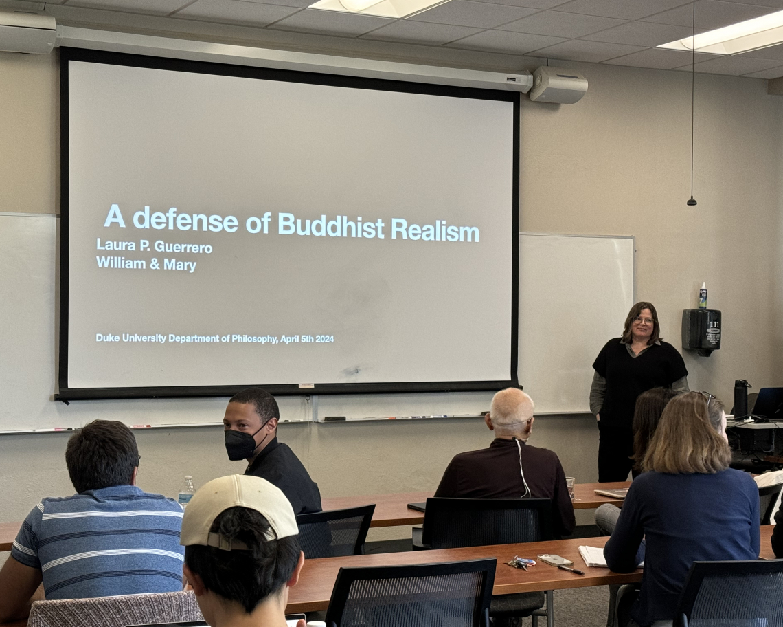 Laura Guerrero in front of a projector that reads "A defense of Buddhist Realism."
