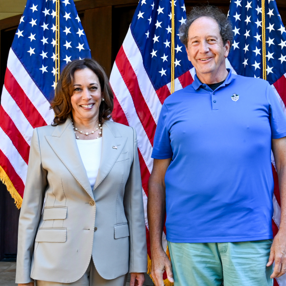 Walter and Kamala Harris stand in front of a row of American flags. 