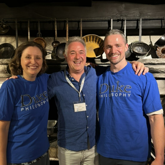 Katherine, Andrew, and Michael standing in front of various ladels and cake pans in a Viennese restaurant. 